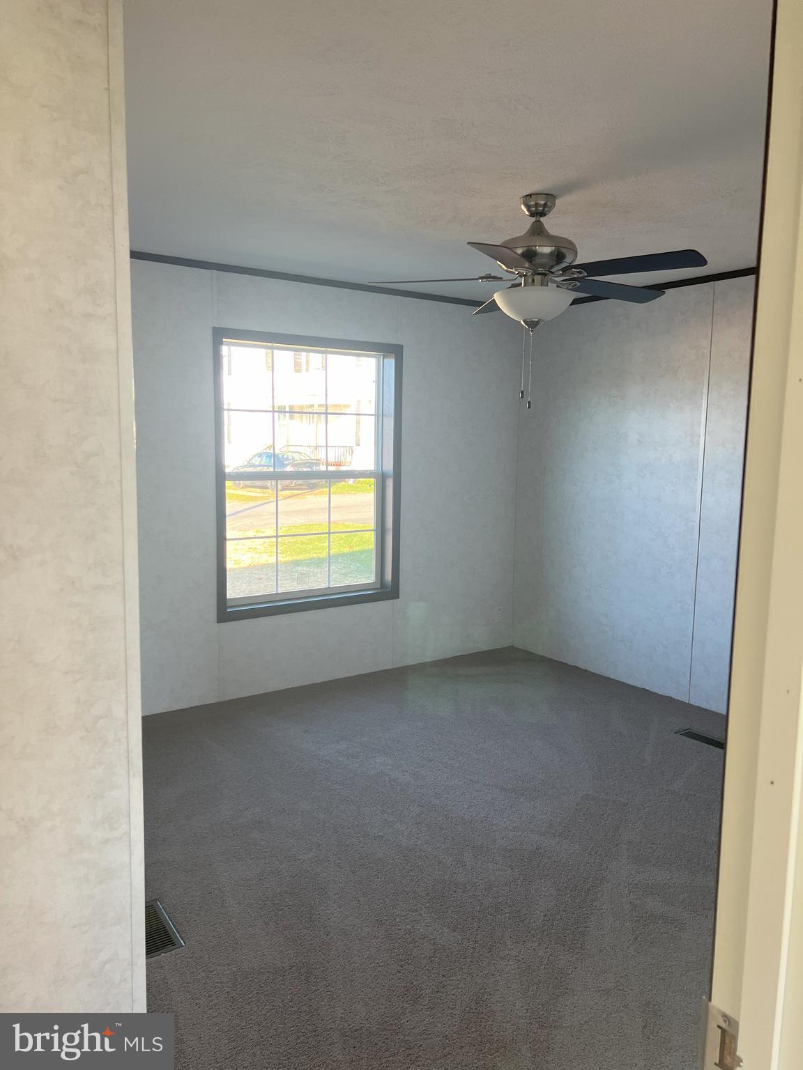 211 Eisenhower Road Moorefield, WV 26836 - Photo 5 of 17 an empty room with windows and fan