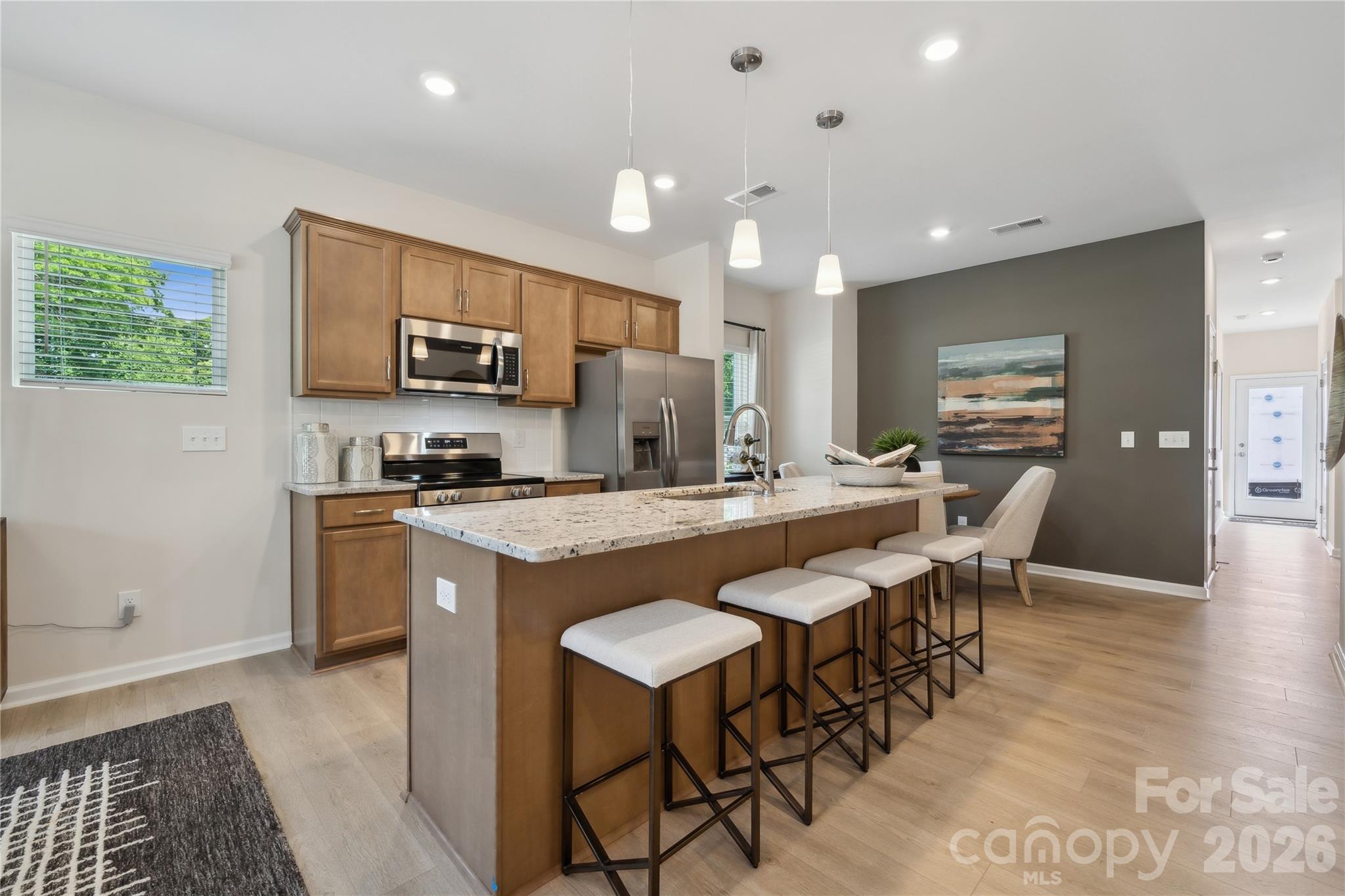 5857 Tuckaseegee Road, Unit 4 Charlotte, NC 28208 - Photo 7 of 23 a large kitchen with kitchen island a sink table and chairs