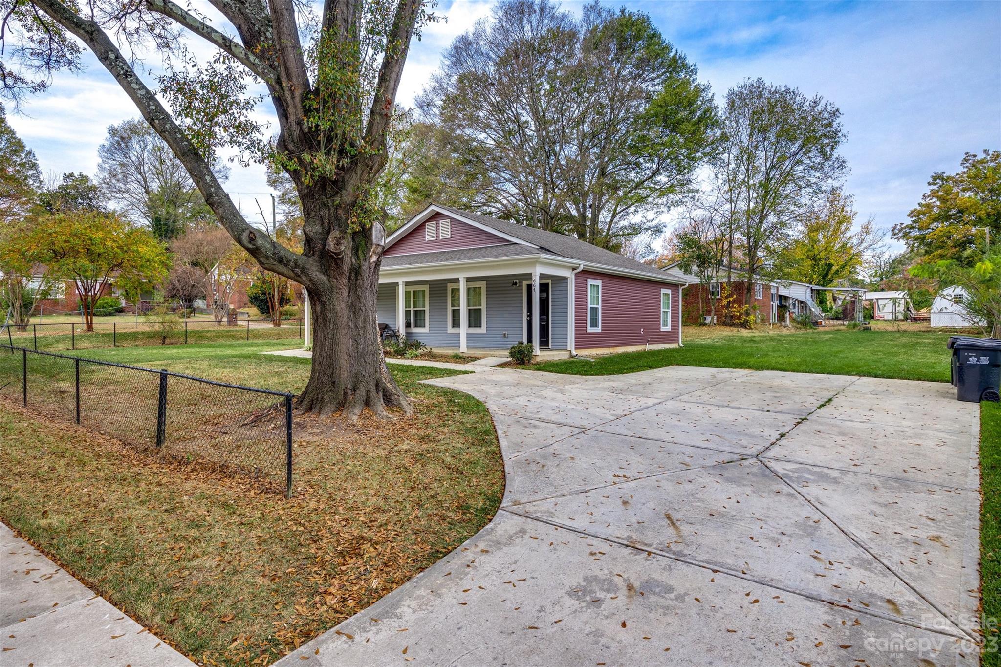 662-664 Reeves Court Charlotte, NC 28208 - Photo 4 of 12 a front view of a house with a yard and large tree