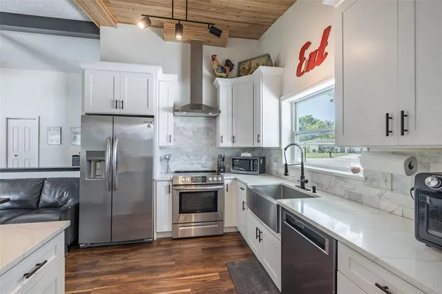 a kitchen with appliances a counter space and cabinets