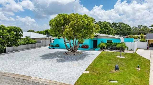 a view of a swimming pool with lawn chairs and plants