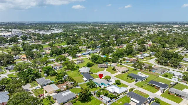 an aerial view of residential houses with outdoor space and trees