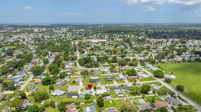 an aerial view of residential houses with outdoor space and trees