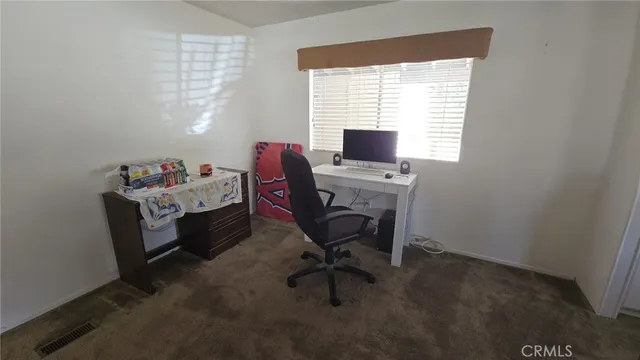 a view of a workspace with furniture and a window