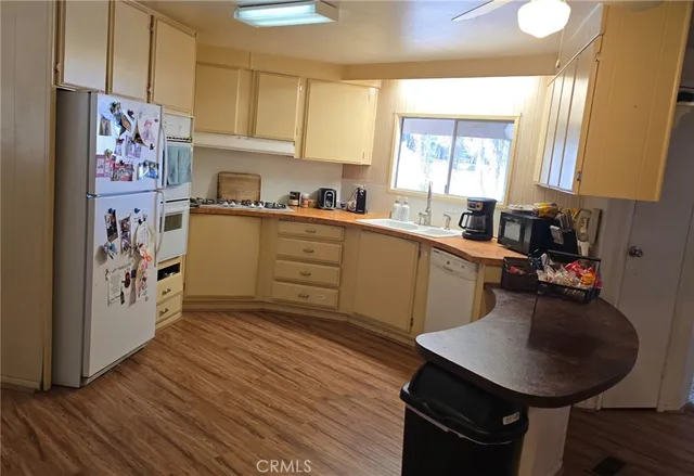 a kitchen with stainless steel appliances a sink a stove a refrigerator cabinets and a dining table