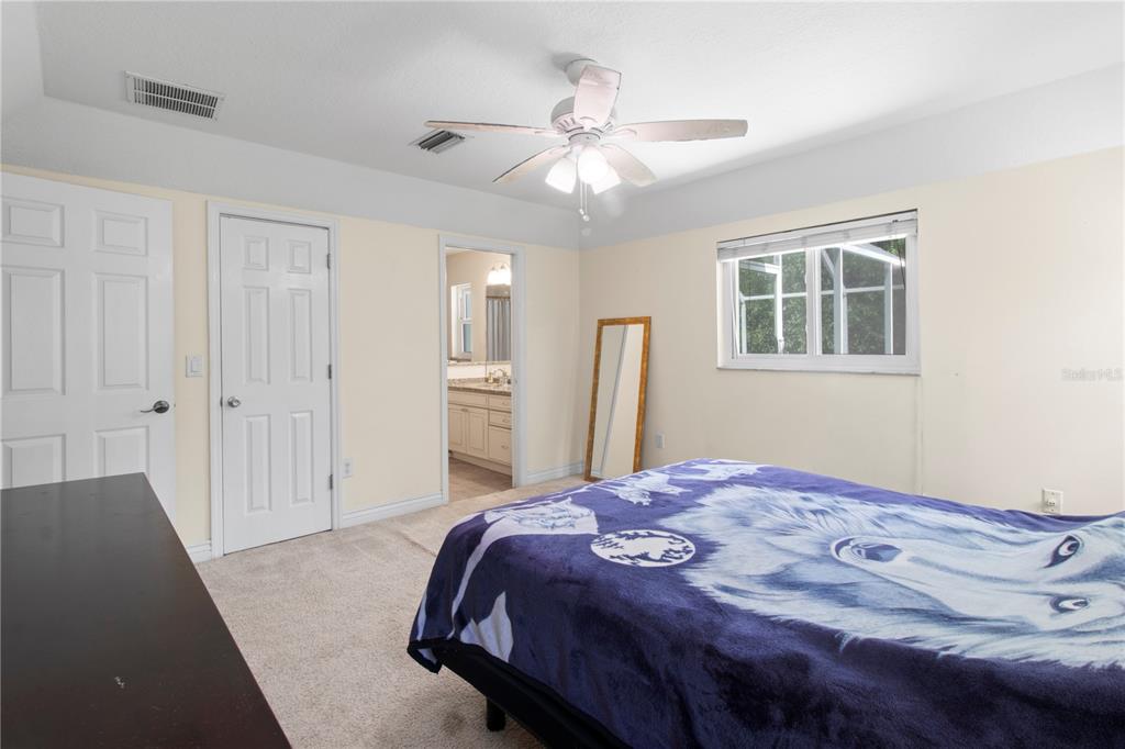 5910 Bella Road Parrish, FL 34219 - Photo 27 of 57 a bedroom with a large bed and a chandelier