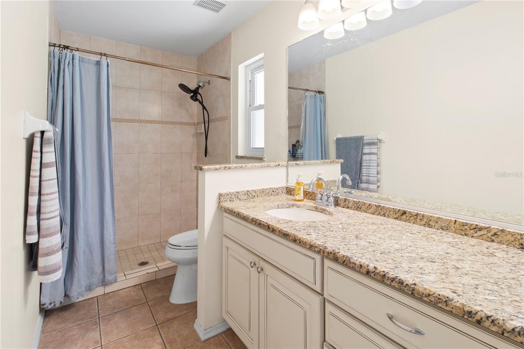 5910 Bella Road Parrish, FL 34219 - Photo 28 of 57 a bathroom with a granite countertop sink toilet and shower