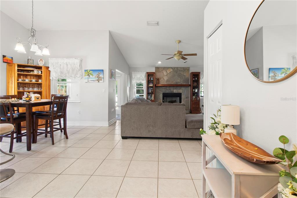 5910 Bella Road Parrish, FL 34219 - Photo 7 of 57 a living room with furniture a dining table and a fireplace