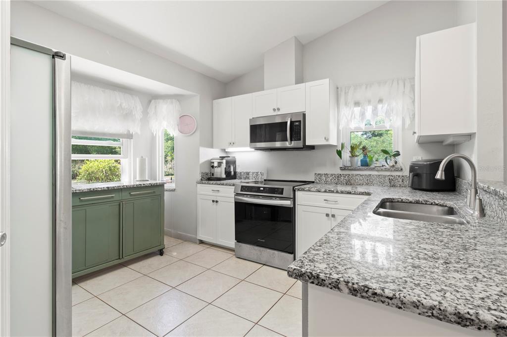 5910 Bella Road Parrish, FL 34219 - Photo 9 of 57 a kitchen with a sink stove top oven and microwave