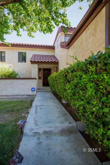 415 Tepatitlan Court Ridgecrest, CA 93555 - Photo 3 of 33 a view of a house with a small yard and a large tree