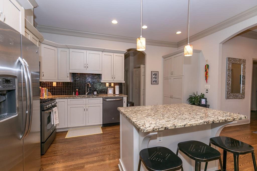 1084 Sanders Avenue Southeast, Unit AB Atlanta, GA 30316 - Photo 20 of 76 a kitchen with granite countertop kitchen island stainless steel appliances a sink stove and refrigerator