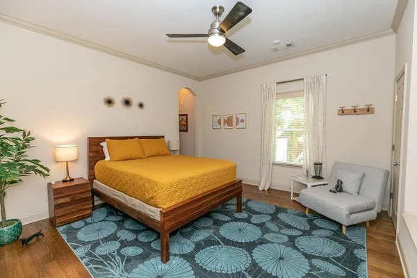 a spacious bedroom with a balcony a bed and wooden floor