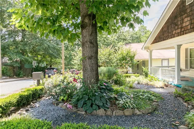 a kitchen with stainless steel appliances kitchen island granite countertop a refrigerator a stove a sink a dining table and chairs with wooden floor