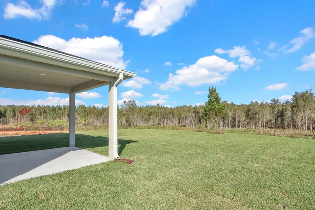 a yellow and white house with a yard