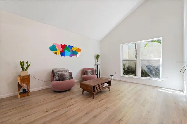 a living room with furniture a large window and wooden floor