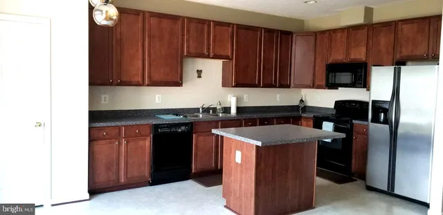 a kitchen with stainless steel appliances granite countertop wooden cabinets a sink and dishwasher