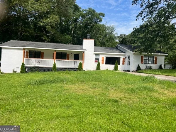 a front view of a house with a yard and trees