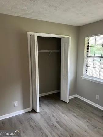 an empty room with wooden floor and closet