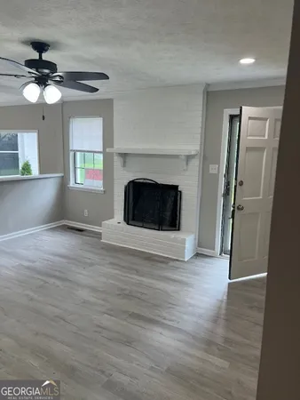 a view of an empty room with a fireplace and a window
