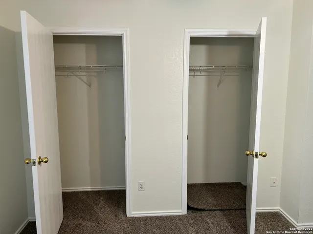 a view of walk in closet with empty racks