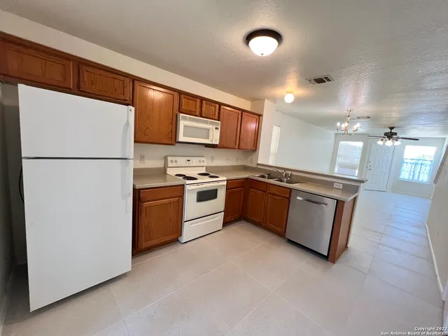 a kitchen with stainless steel appliances a refrigerator sink and white cabinets