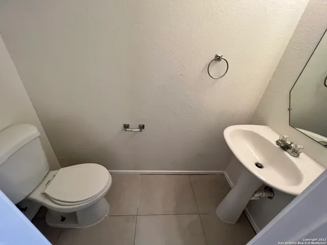 a bathroom with a sink toilet and a mirror