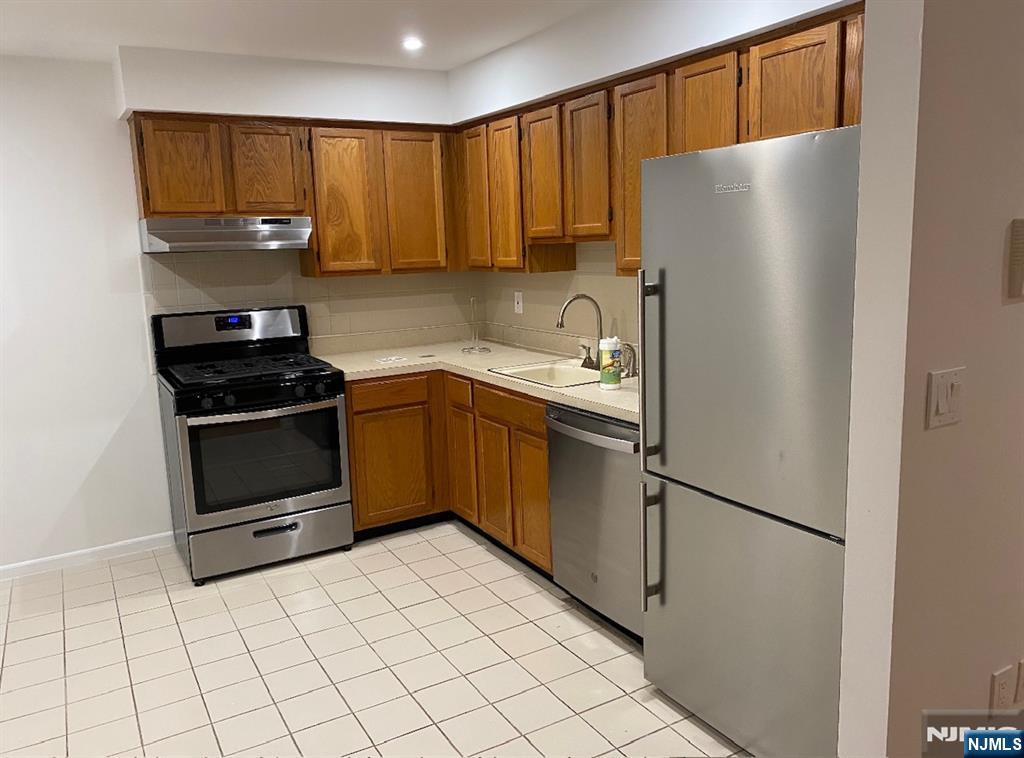 a kitchen with a refrigerator sink and cabinets