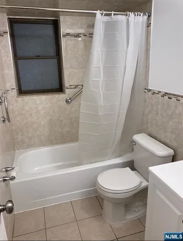 a white toilet sitting next to a bath tub