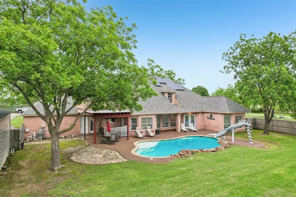 a view of a house with a big yard potted plants and large tree