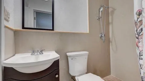 a bathroom with a sink toilet and a mirror