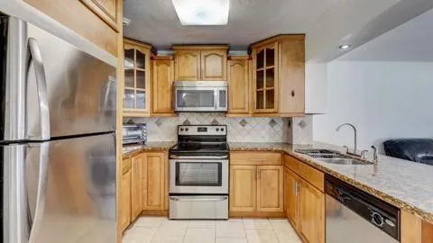 a kitchen with stainless steel appliances white cabinets and a refrigerator