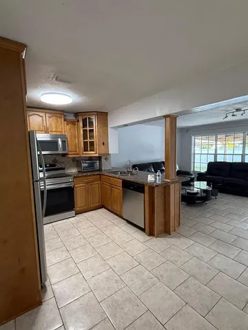 a kitchen with stainless steel appliances granite countertop a stove top oven a sink dishwasher and a refrigerator