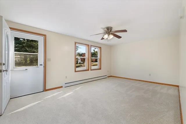 an empty room with windows and fan