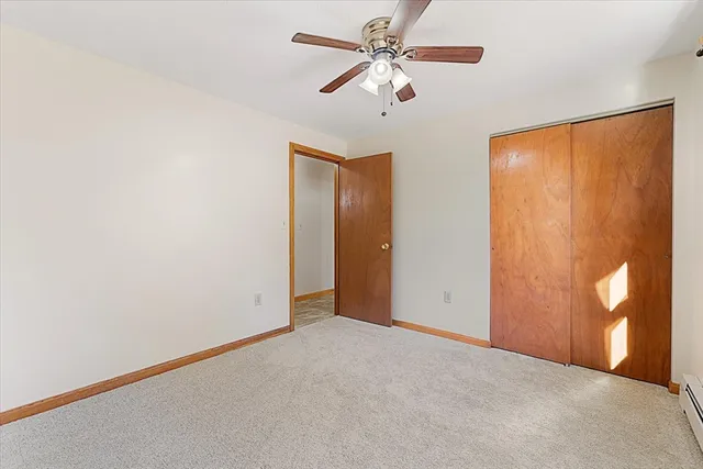 an empty room with window and ceiling fan