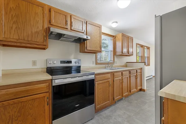 a kitchen with stainless steel appliances granite countertop a stove a sink and a microwave
