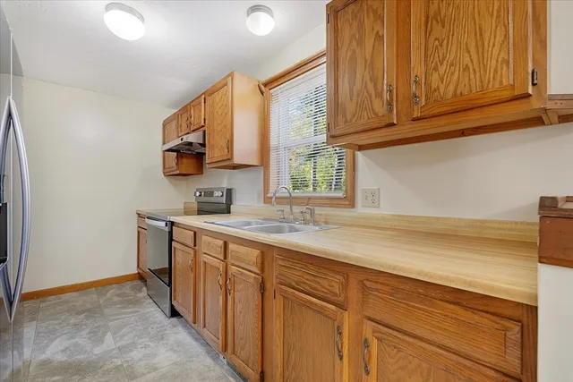 a kitchen with stainless steel appliances granite countertop a sink dishwasher stove and cabinets