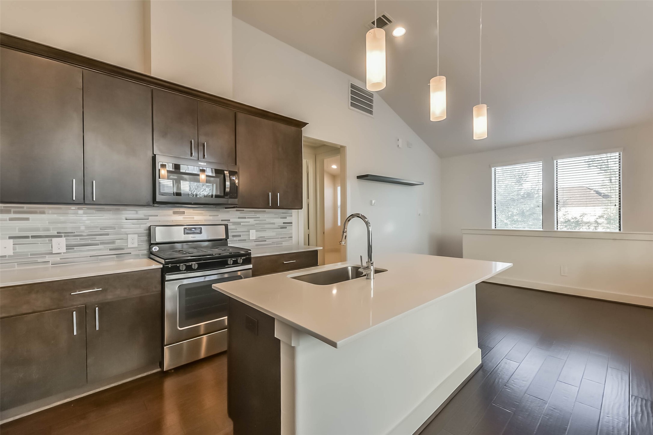 3206 North MacGregor Way, Unit A Houston, TX 77004 - Photo 13 of 30 a kitchen with stainless steel appliances a sink a stove a microwave a center island and cabinets