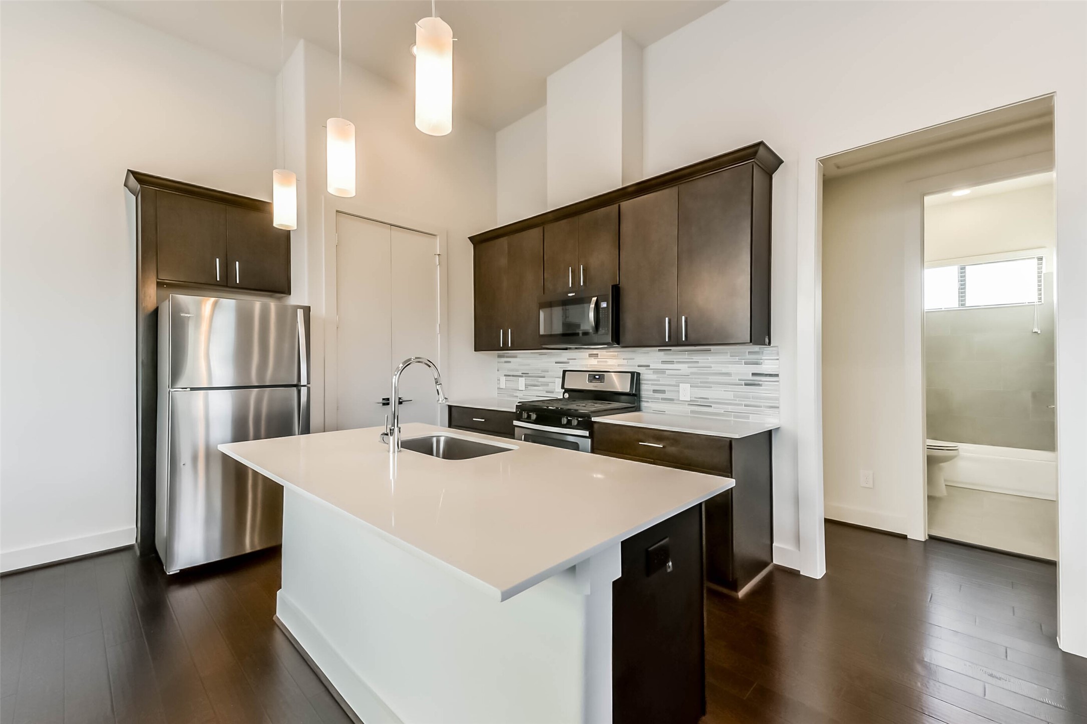 3206 North MacGregor Way, Unit A Houston, TX 77004 - Photo 14 of 30 a kitchen with a sink a microwave a refrigerator and cabinets