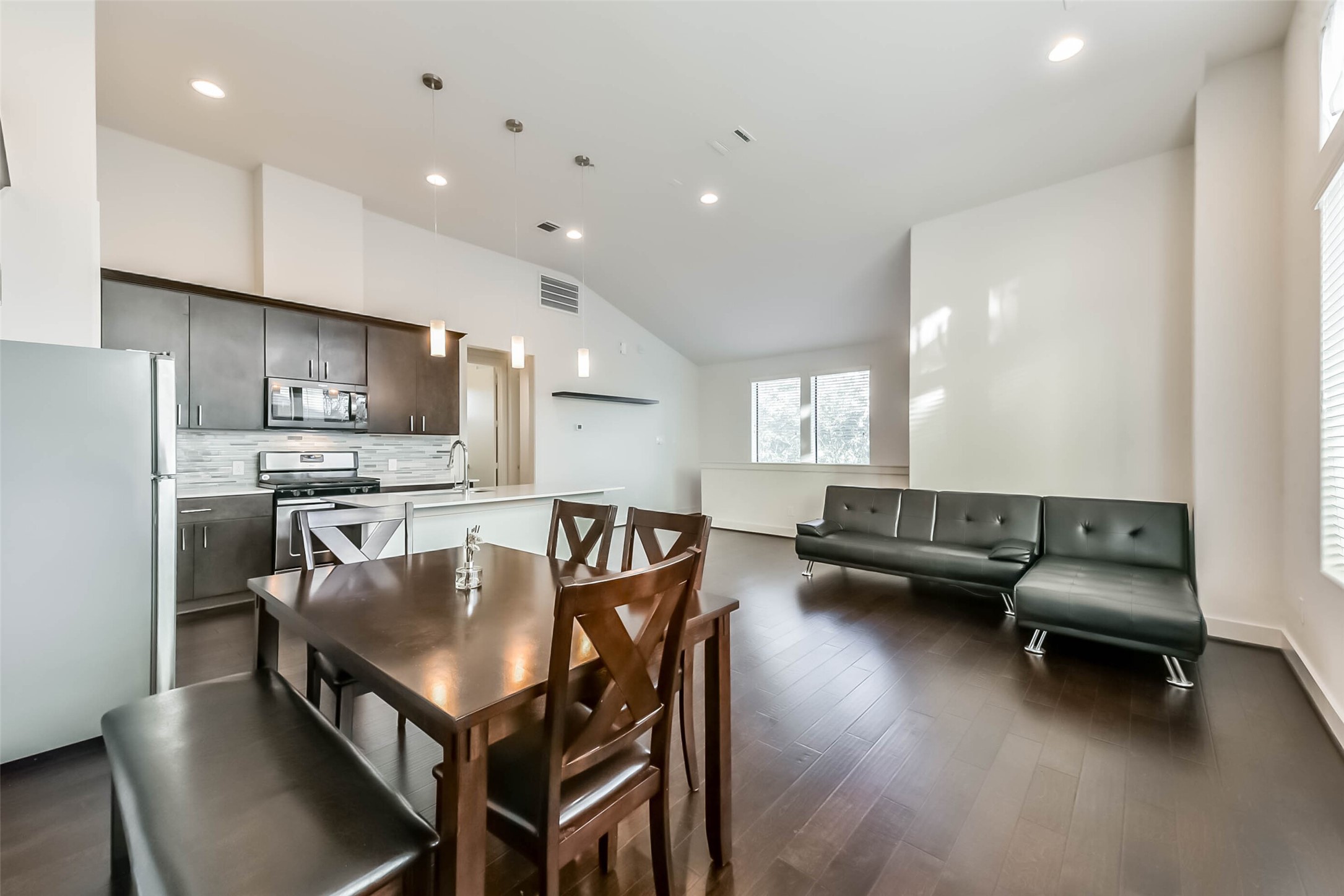 3206 North MacGregor Way, Unit A Houston, TX 77004 - Photo 16 of 30 a kitchen with a table chairs refrigerator and microwave