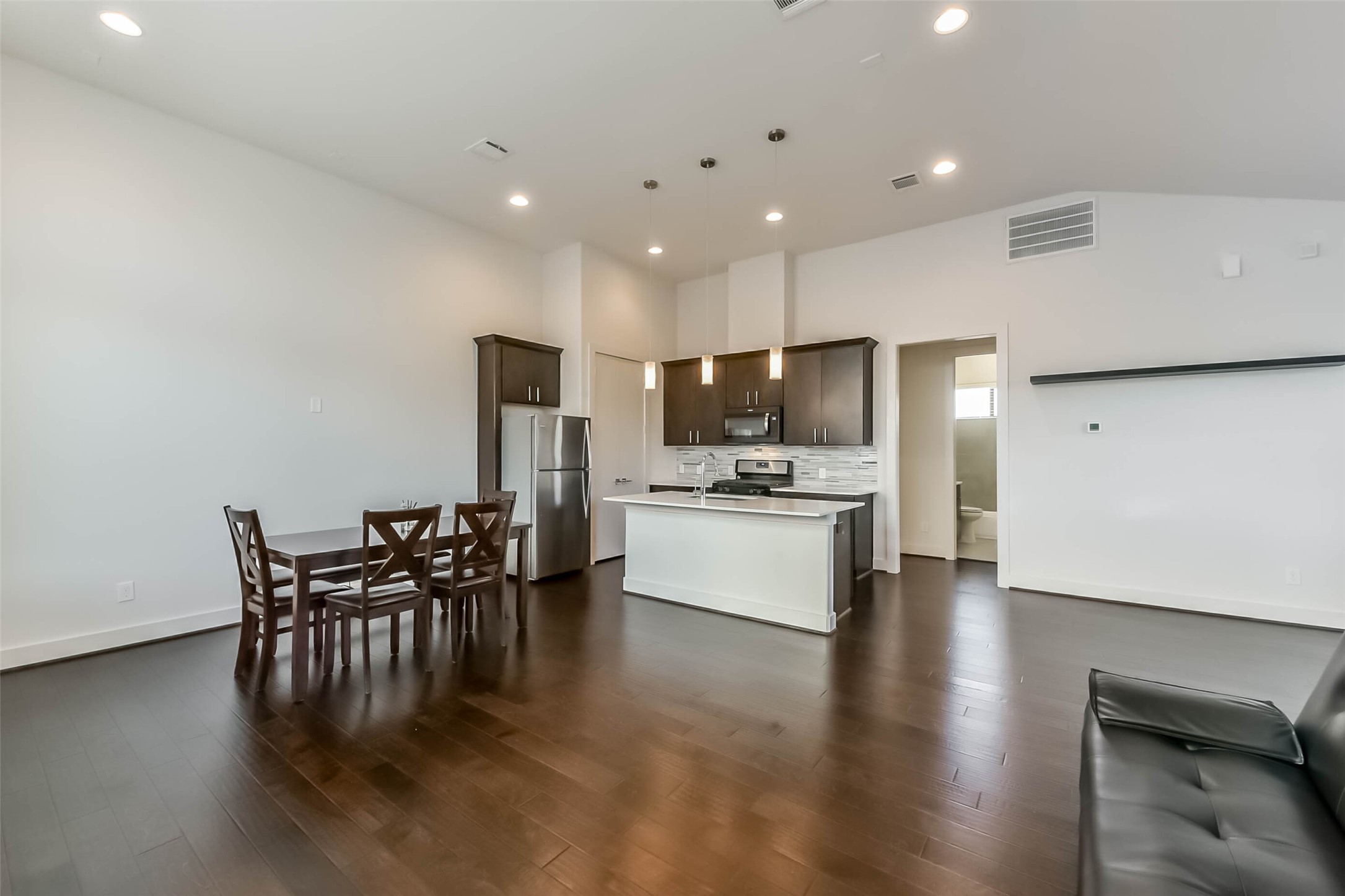 3206 North MacGregor Way, Unit A Houston, TX 77004 - Photo 17 of 30 a kitchen with a dining table chairs refrigerator and cabinets