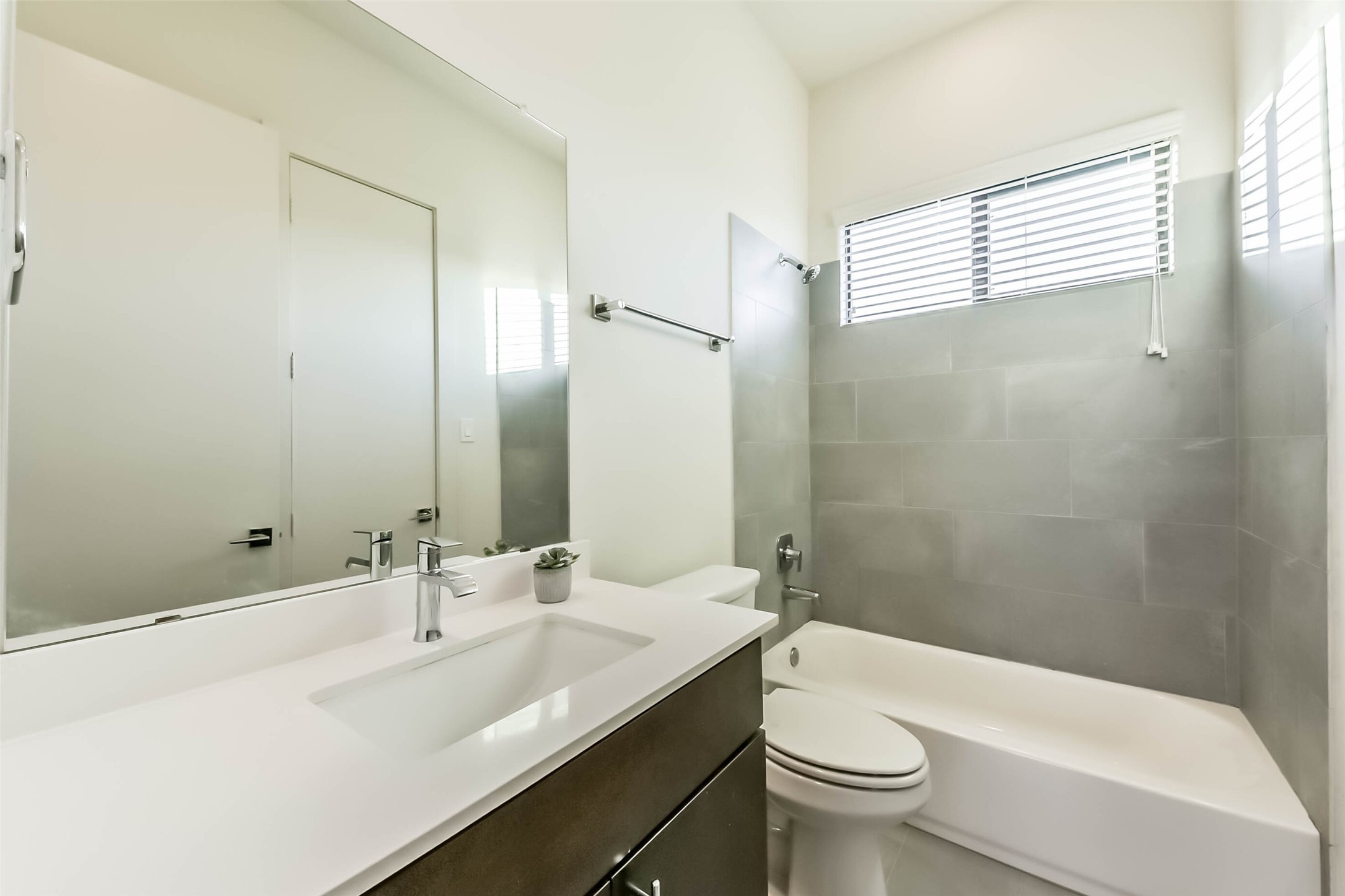 3206 North MacGregor Way, Unit A Houston, TX 77004 - Photo 25 of 30 a bathroom with a sink a toilet a mirror and a tub