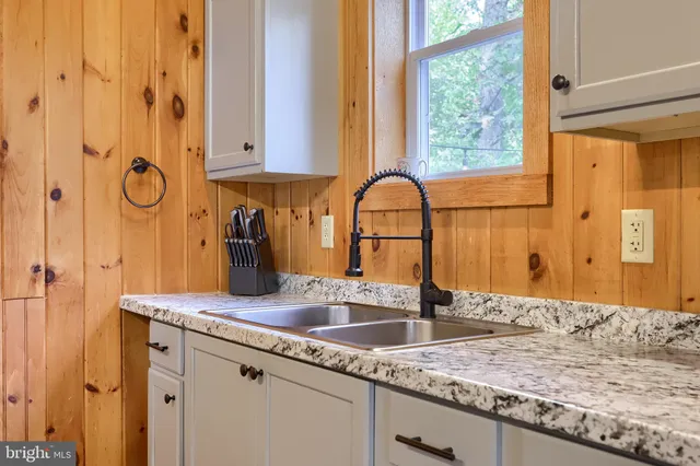 a bathroom with a granite countertop toilet sink and mirror