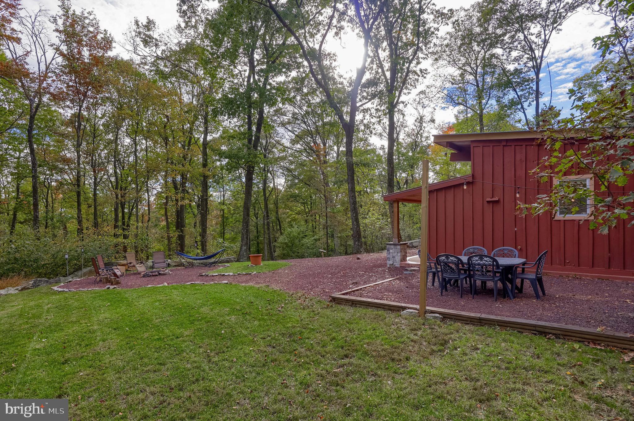 485 Airport Road Bethel, PA 19507 - Photo 40 of 71 a view of a backyard with table and chairs potted plants and a large tree
