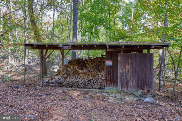 an aerial view of residential house with outdoor space and trees all around