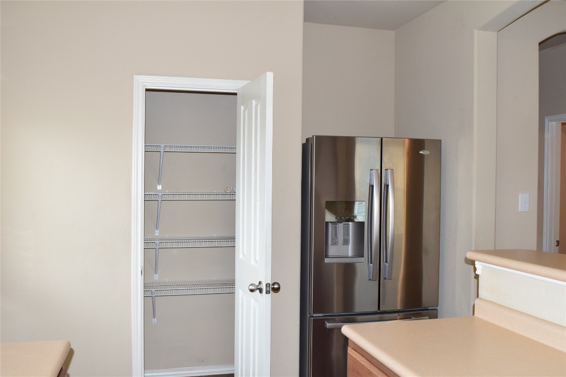 11717 Alexs Lane Austin, TX 78748 - Photo 8 of 32 a room with a refrigerator and cabinets