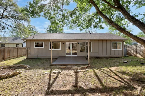 a view of a small house with a tree in the background