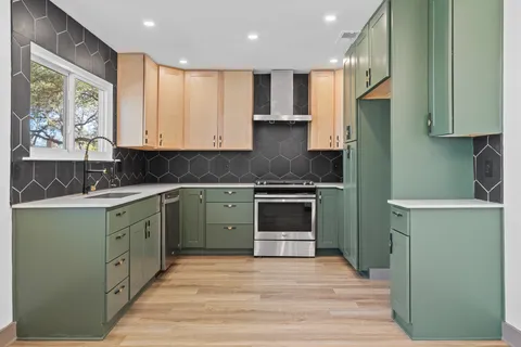 a kitchen with granite countertop a stove a sink and a microwave