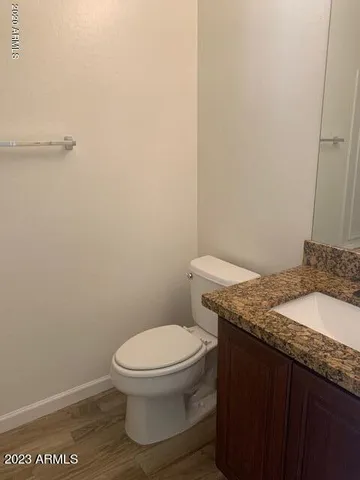 a bathroom with a granite countertop toilet and a sink