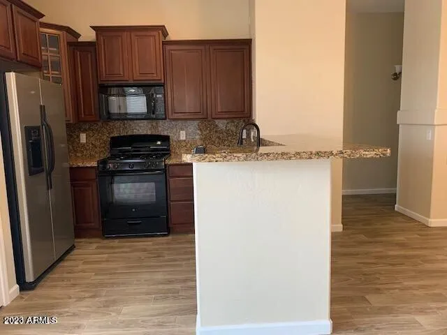 a kitchen with stainless steel appliances granite countertop a refrigerator and a stove