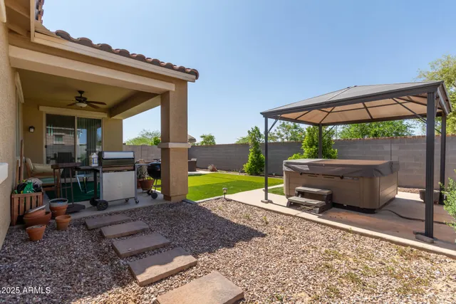 a view of a backyard with table and chairs under an umbrella